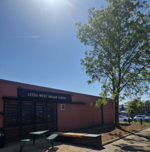 building by a tree sunshine behind blue skies leeds carbbean and african centre