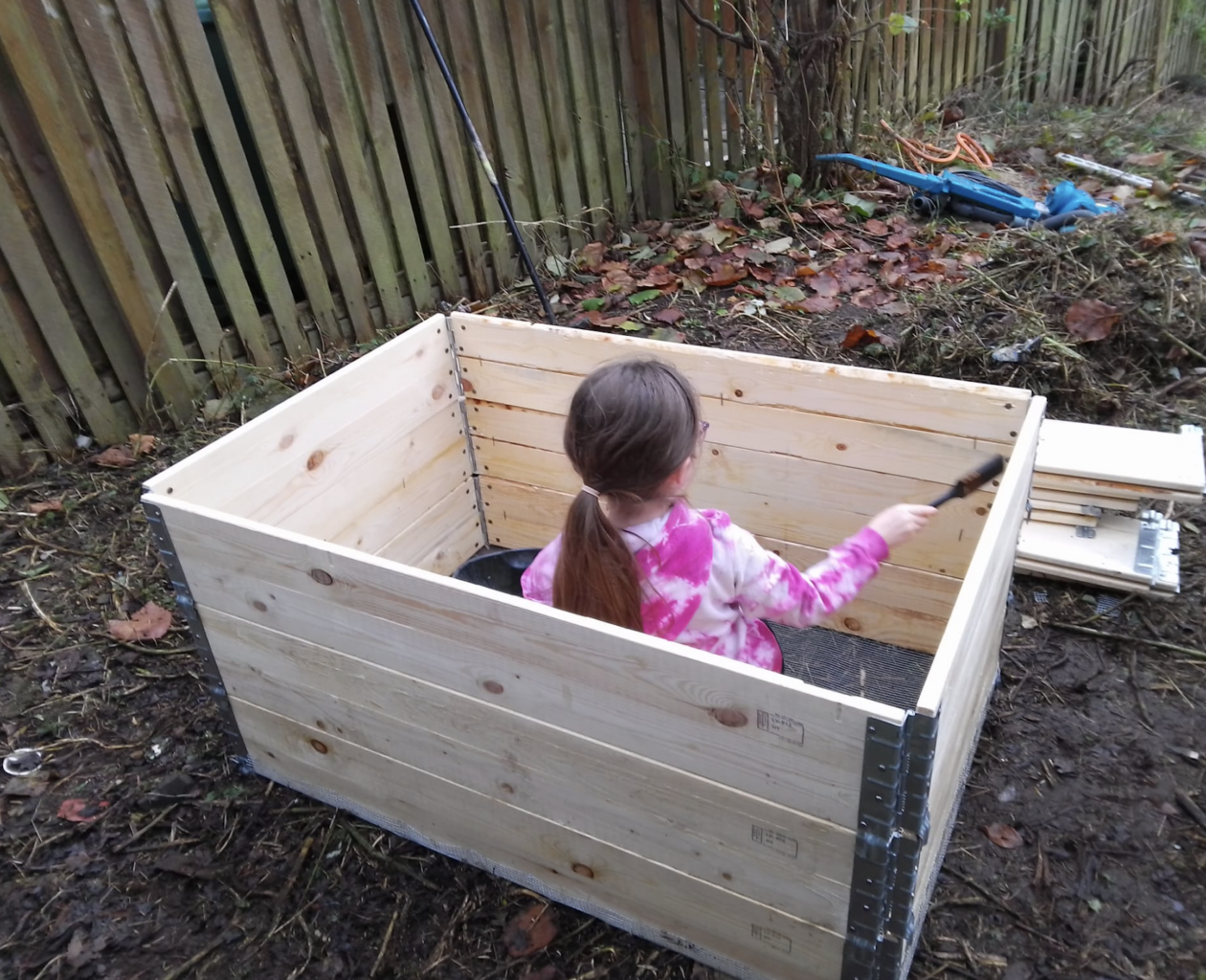 Child in compost bin child in a compost bin in a community garden in a pink outfit in killingbeck orchard