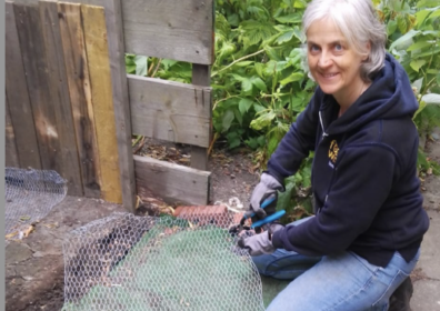 Annie by a compost bin at chapeltown compost collective