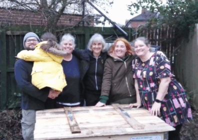 people by a compost bin